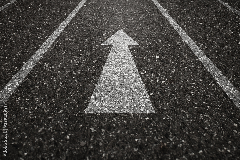 Asphalt road with an arrow pointing forward on the surface. An image of ...