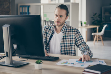 Poster - Photo of business finance administrator guy computer table look check graphics charts on paper compare with online numbers stats wear casual shirt sit modern office indoors