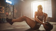 © Gorodenkoff - Strong and Fit Beautiful Athletic Woman in Sport Top is Doing Core and Ab Exercises with Ball in a Loft Style Industrial Gym with Motivational Posters. It's Part of Her Cross Fitness Training Workout.