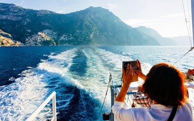Wall Mural - Tourist taking photos during cruise in Tyrrhenian Sea Positano reflex