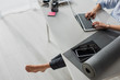 © LIGHTFIELD STUDIOS - cropped view of barefoot businesswoman working on laptop at workplace with yoga mat, notepad, smartphone and eyeglasses