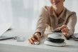 © LIGHTFIELD STUDIOS - cropped view of businesswoman sitting at workplace with zen stones, smartphone and laptop