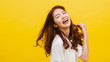 Happy excited young funny Asian lady listening to music and dancing in casual clothing over yellow background. Human emotions, facial expression, studio portrait, lifestyle concept.