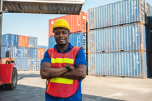 Black Foreman Worker Working Control The Crane And Forklift At Container Cargo Harbor To Loading Containers. African Dock Male Staff For Logistics Import Export Shipping Concept.