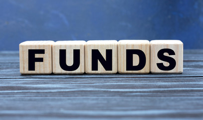 concept word FUNDS on wooden cubes on a gray background