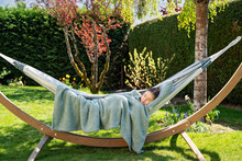 Young Relaxed Girl Sleeping Peacefully In Hammock In Garden At Home At Bright Sunny Day. Slow Living, Gadget Detox And Weekend Leisure Activity. Quarantine And Self Isolation Period