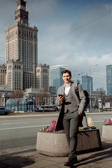 Happy business people, working outside, entrepreneur and work freedom communication technology.A guy in a headset in a big city is holding a phone.