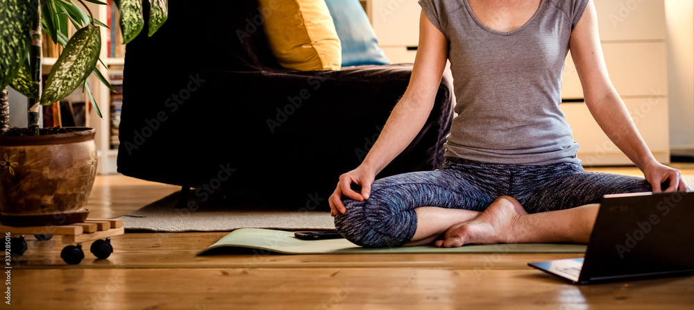 woman doing yoga workout at home watching videos online on laptop computer - obrazy, fototapety, plakaty 