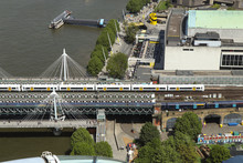 View On Beautiful Railway Bridge Across Thames River To Famous Charing Cross Railway Station. Colored Train Whizz Along The Track To Pick Up More Tourists. London Atraction. United Kingdom