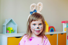 Adorable Toddler Girl With Bunny Face Painting And Ears On The Head
