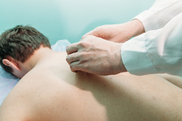 chiropractor massaging back of patient that lying on massage table in hospital