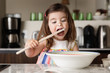 © Lisa Tichané - Cute toddler girl tasting food in kitchen