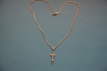 Golden necklace with heart on black background catholic cross with heart