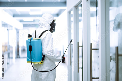 Fotografía Disinfecting of office to prevent COVID-19, Man in protective hazmat suit with with spray chemicals to preventing the spread of coronavirus, pandemic in quarantine city