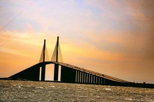 Low Angle View Of Silhouette Sunshine Skyway Bridge In Front Of Sea During Sunset