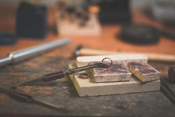 Wall Mural - Different goldsmiths tools on the jewelry workplace. Jeweler at work in jewelry. Desktop for craft jewelry making with professional tools. Close up view of tools.