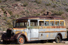 Side View Of Old Vintage School Bus Abandoned In The Desert