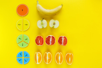 Wall Mural - Colorful math fractions and apples, oranges, banana as a sample on yellow background or table. Interesting fun math for kids. Education, back to school concept. Geometry and mathematics materials.