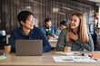 © Drobot Dean - Photo of laughing students using laptop and writing in exercise book