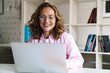 © Drobot Dean - Photo of joyful woman wearing eyeglasses smiling and using laptop