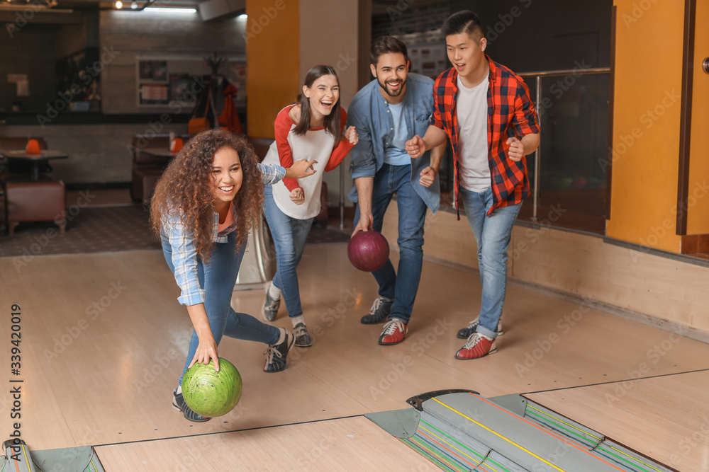 Friends playing bowling in club