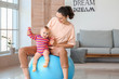 © Pixel-Shot - Young sporty mother and her baby doing exercises with fitball at home