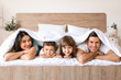 © Pixel-Shot - Happy family in bedroom at home