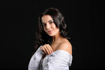 Young woman with beautiful healthy hair on dark background