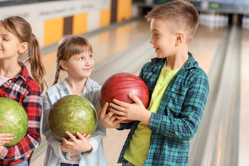 Poster - Little children playing bowling in club