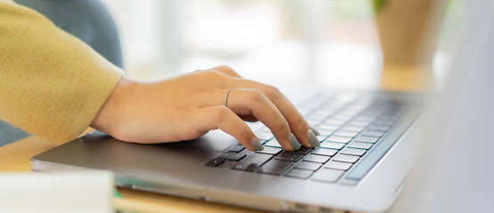 Wall Mural - close up employee woman hand typing on keyboard laptop to search optimizations on website for work f
