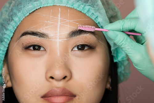 Master makes eyebrows. Eyebrow lamination. The girl makes eyebrows in the salon. Beautiful eyebrow shape. Professional eyebrow lamination. Cosmetic procedures, Brow architecture.