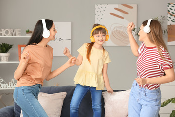 Canvas Print - Happy lesbian couple with little adopted girl listening to music and dancing at home