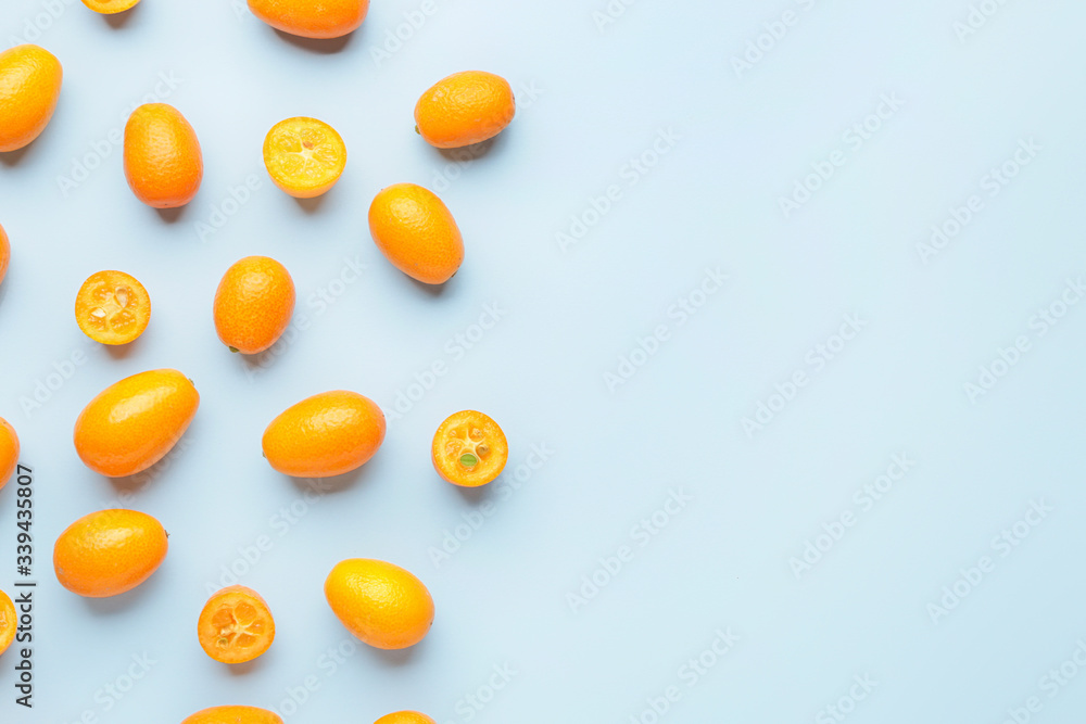 Tasty kumquat fruit on color background
