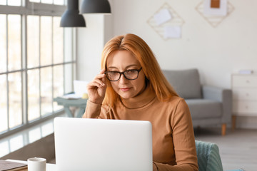 Sticker - Mature woman using laptop for online learning at home