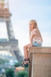 Adorable toddler girl in Paris background the Eiffel tower during summer vacation