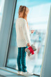 Little girl in airport near big window while wait for boarding