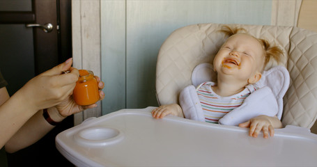 Caucasian mother feeding baby with spoon