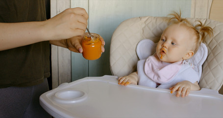 Caucasian mother feeding baby with spoon