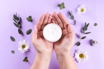 Wall Mural - Revitalizing hand cream for healing and recovery after excessive use of soap and disinfectants. Adult woman applying moisturizing lotion. Copy space, close up, background, flat lay, top view.