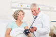 © Robert Kneschke - Arzt kontrolliert den Blutdruck einer Patientin