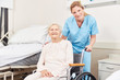 © Robert Kneschke - Altenpflegerin und Senior Frau im Rollstuhl