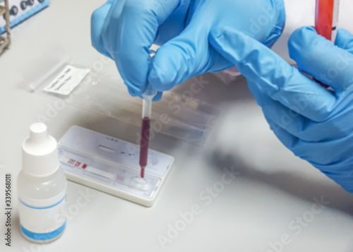 COVID-19 or coronavirus rapid test concept. Blur background scientist or lab technologist working in university research laboratory testing blood sample in science room examination hospital.