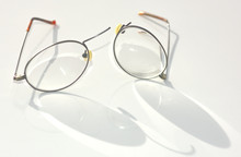 A Pair Of Titanium Wire Rim Eye Glasses That Have Broken And Split Apart On The Nose Bridge Section.