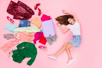 Poster - Top above high angle view full body profile side photo of astonished girl have travel trip fall her suitcase clothes fly scream lay wear white denim isolated pastel color background