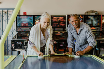 Wall Mural - Senior couple playing table hockey