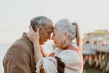 Senior Couple Intimately Embracing By The Sea
