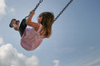 Little girl playing at playground during recess on swing and slide