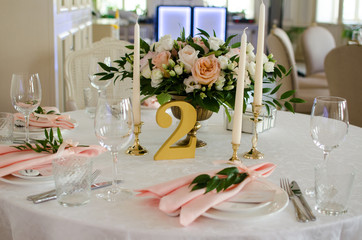 Table for wedding with white ang light pink flowers  in restaraunt 