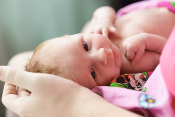 Wall Mural - A small newborn girl in the arms of her mother. Reliable protection motherly love