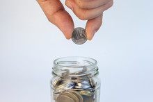 Glass Jar With Money On A White Background. Hand With A Coin. Coin One Russian Ruble
